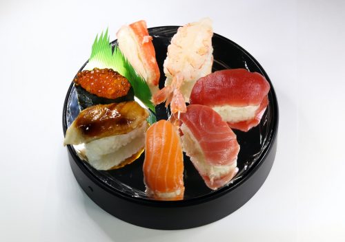 sliced meat with green leaf on black ceramic plate