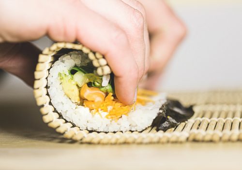 person rolling sushi